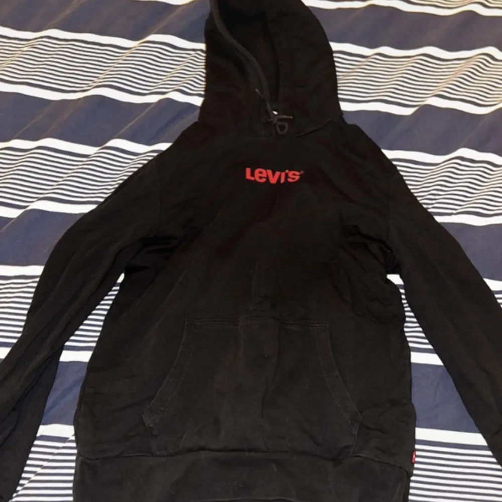 Svart Levi’s hoodie i storlek M. Bra skick men har slitning på snöret som syns på sista bilden.. Hoodies.