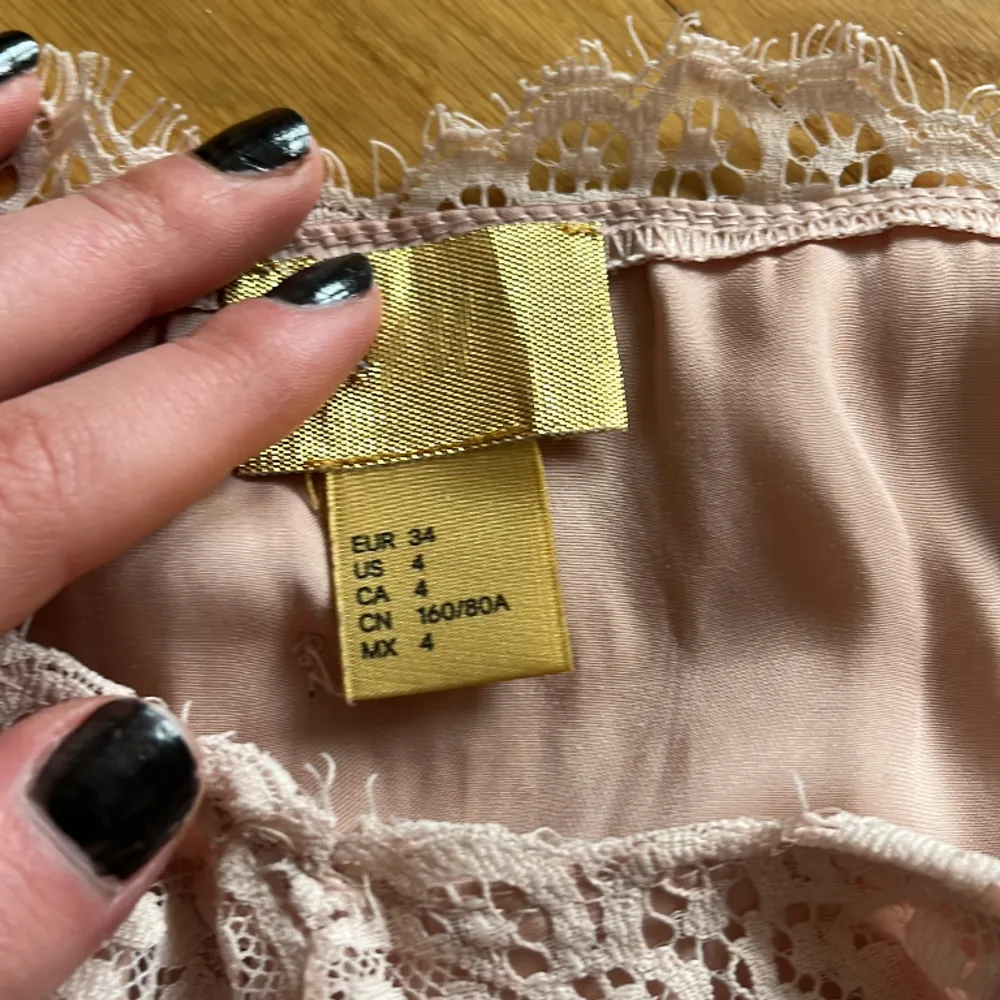 Ett jätte fint ljus rosa linne med spets detaljer, säljer då det är för stort, storlek är jag tveksam på men skulle tror typ S/M. Toppar.