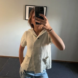 Söt stickad kortärmad kofta med luva - Så söt kortärmad beige kofta med luva. Använd en gång. Storlek s. Inga defekter. Köpt second hand