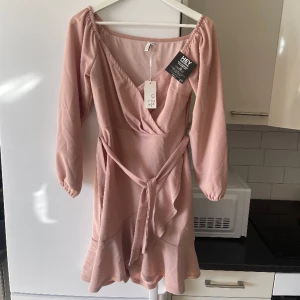 Rosa klänning (prislappar kvar) - Finaste klänningen jag köpt!! Men kom aldrig till användning tyvärr (prislappar kvar) så dags att sälja vidare. Stretchig och skönt material, går att knyta där framme 💕