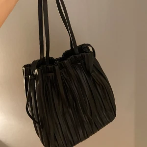 Väska - Fin plisserad väska från Zara i skinnimitation. Väskan är rymlig och har både ett långt och ett kort band beroende på hur man vill ha den. Nyskick 