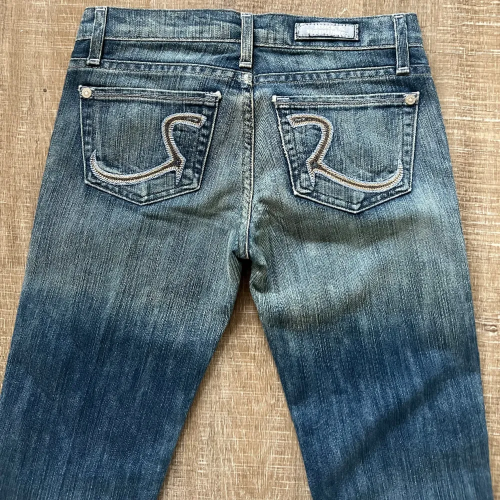 Skitsnygga vintage bootcut jeans köpta secondhand i USA! Jättebra skick! Skulle säga de passar en 34. Extra långa! Lågmidjade. Ca 37 cm i midjemått. Innerbenslängd ca 90 cm . Jeans & Byxor.
