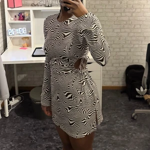 Klänning - Klänning i coolt mönster med cut outs! Aldrig använd endast testad. 