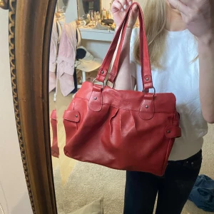 Röd Daniel Hechter väska  - Köpt på sellpy! Tillkommer en rem som man kan sätta på om man vill ha den längre eller crossbody❣️❣️❣️ Dragkedjan går upp ibland