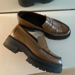 Loafers - Bruna loafers från Samsøe Samsøe. Inköpta sommaren 2022 för ca 2000kr. Sparsamt använda och i väldigt bra skick. Jag har storlek 37,5 och dessa i 38 har funkat för mig. 