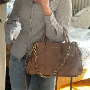 Sjukt snygg Guess väska - Guess väska som köptes för ca 2000 kr för 6 år sedan. Använd 1 gång. Verkligen jätte fin väska som skulle behöva lite kärlek, väldigt bra väska med utrymme. 💞💞