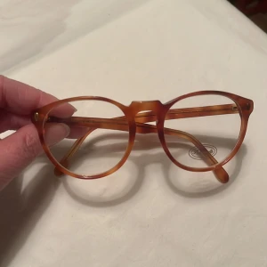 Vintage Glasögonbåge från 80 talet Faconnable  - Exklusive glasögonbåge från Faconnable från 80 Talet, ljusbrun melerad Kommer från en nedlagd Optikbutik, aldrig använd Hela bågens bredd 130 mm Glasets storlek, bredd 49 mm, djup 45 mm 