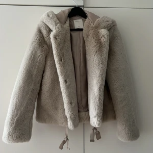 Fluffig jacka från Sandro  - Knappt använd, super mysig med stor luva. Är från fina märket Sandro Paris. Vet inte vilken storlek det är men skulle gissa på S/M