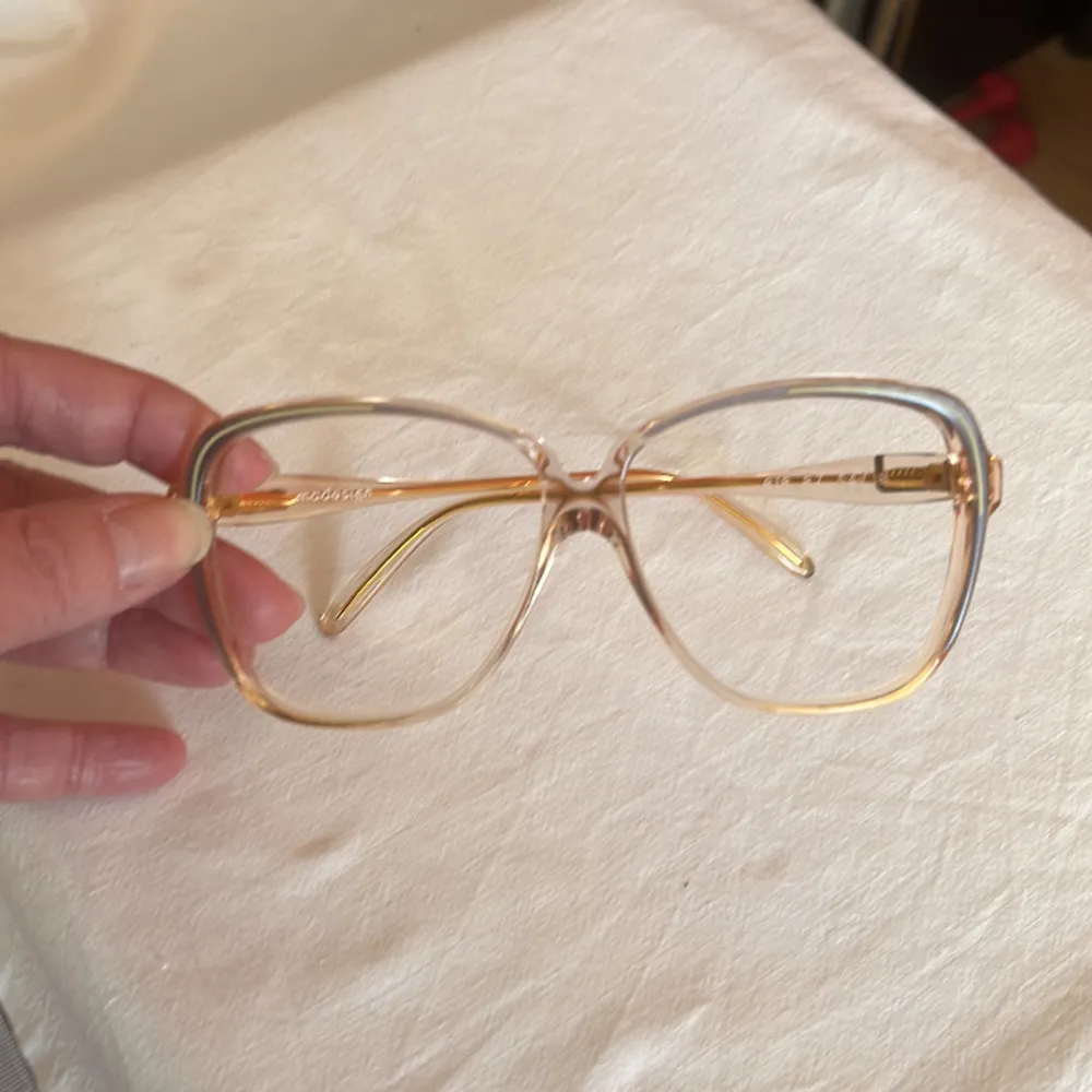 Vintage glasögonbåge från 80 talet Kommer från en nedlagd Optikbutik, aldrig använd Hela bågens bredd 130 mm Glasets storlek, bredd 55 mm, djup 52 mm. Övrigt.