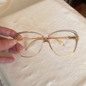 Vintage Glasögonbåge från 80 Talet - Vintage glasögonbåge från 80 talet Kommer från en nedlagd Optikbutik, aldrig använd Hela bågens bredd 130 mm Glasets storlek, bredd 55 mm, djup 52 mm