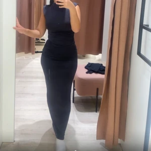 Svart långklänning - Säljer en elegant grå två delars set i tight passform. Klänningen är ärmlös och perfekt för både fest och nyår. Den har en stilren design som framhäver figuren på ett snyggt sätt. Perfekt för dig som vill ha en klassisk och tidlös look.Hela settet 150 kr. Endast topp 60 kr och kjol 90 kr.❤️