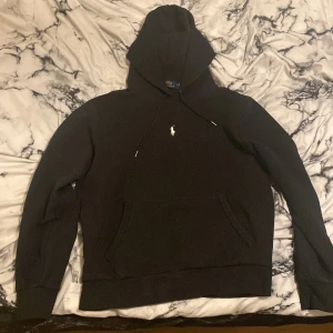 Svart hoodie från Polo Ralph Lauren - Säljer en klassisk svart hoodie från Polo Ralph Lauren i storlek M. Perfekt för höst och vinter, och den är i mycket bra skick. Kontakta för fler bilder.