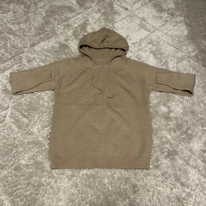 Stickad huvtröja - Säljer en beige stickad huvtröja i oanvänt skick. Perfekt för höst, vinter och vår med sin mjuka och bekväma passform. Den har långa ärmar och en praktisk huva med snörning. Passar perfekt för en avslappnad stil! Skick 10/10. Hör av dig vid funderingar. 