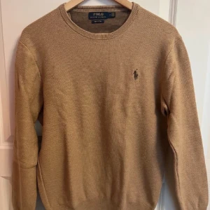 Beige tröja från Polo Ralph Lauren - Säljer en snygg beige tröja från Polo Ralph Lauren. Den är i mycket bra skick och har en klassisk design med rund hals och det ikoniska logotypbroderiet på bröstet. Perfekt för både höst och vår. Passar till både vardag och fest!