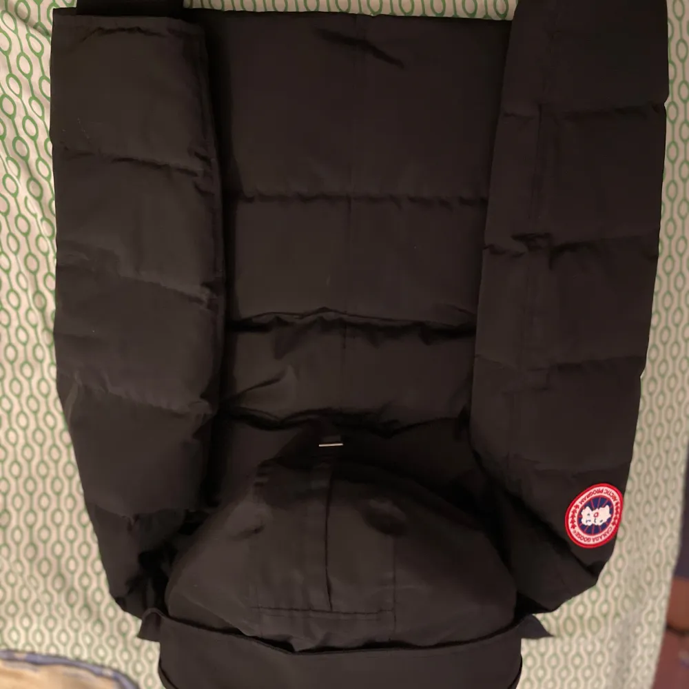 Säljer en svart dunjacka från Canada Goose i mycket bra skick. Jackan har en varm och vadderad design med huva och knappar. Perfekt för kalla vinterdagar. Den är långärmad och har en klassisk stil som passar till det mesta. Hög kvalitet och superbekväm!. Jackor.