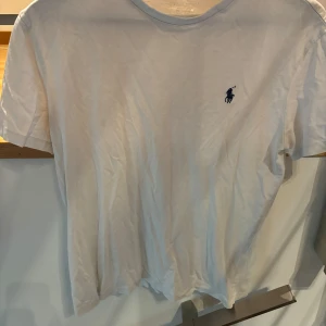 Vit t-shirt från Ralph Lauren - Säljer en klassisk vit t-shirt från Ralph Lauren. T-shirten är i bomull och har en normal passform. Den är kortärmad och i bra skick, men har en liten defekt vid kragen. Nypris 700