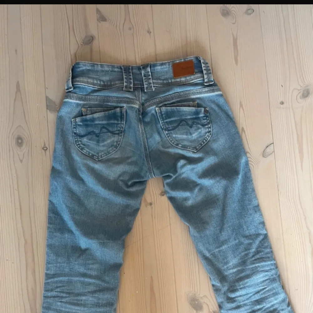 Säljer ett par snygga ljusblå jeans i super skick. De har inga som helst defekter och är lågmidjade 💞.  De är W25 men är ganska stretchiga runt midjan så funkar även för större storlekar. Jeansen är lite för långa för mig som är 163💗. Jeans & Byxor.