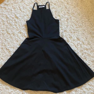 Svart klänning med smala axelband - Snygg svart klänning med smala axelband, mycket stretchigt tyg. Klänningen är i storlek XS, från Ginatricot, aldrig använd. Pris går att diskutera och jag kan skicka bild på hur den ser ut på💕
