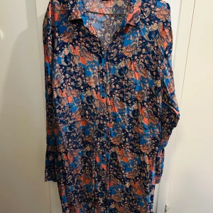 Mönstrad klänning från Bodyflirt - Säljer en färgglad klänning från Bodyflirt i storlek 48. Den har ett vackert paisleymönster i blått, orange och rosa. Klänningen är långärmad och perfekt för både vardag och fest. Materialet känns mjukt och bekvämt mot huden. Ett måste för garderoben om du gillar färg och mönster!
