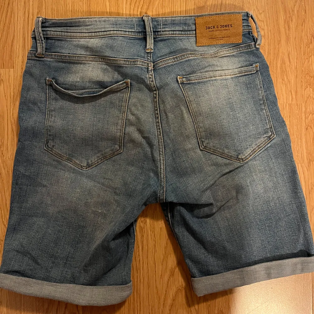 Säljer ett par snygga jeansshorts från Jack & Jones i storlek S. Shortsens längd är precis ovanför knäna och de har en snygg uppvikt kant. Hör av dig om du har frågor eller funderingar!. Shorts.