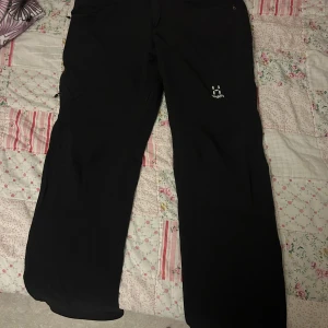Svarta byxor från Haglöfs - Säljer ett par svarta byxor från Haglöfs i storlek L. De är perfekta för utomhusaktiviteter med en bekväm passform och slitstarkt material. Byxorna har praktiska fickor och en stilren design. Perfekta för höst- och vinteräventyr! Pris kan diskuteras vid snabb affär