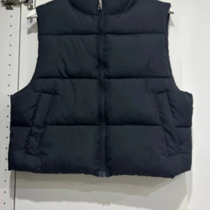 Svart dunväst med dragkedja - Säljer en svart dunväst i normal passform. Västen har en praktisk dragkedja framtill och är perfekt för höst och vinter. Den är stilren och enkel att matcha med olika outfits.