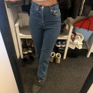 Blå högmidjade jeans - Säljer ett par klassiska blå högmidjade jeans i mycket bra skick. De har en straight passform och är perfekta för både vardag och fest. Jeansen är bekväma och stilrena, ett måste i garderoben! Passar perfekt till sneakers eller boots. Säljer ett par likadana i ljusblåa 🩵