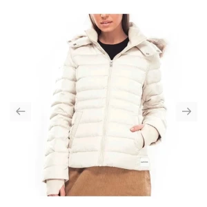 Beige pufferjacka från Calvin Klein Jeans - Helt ny och oanvänd beige pufferjacka från Calvin Klein Jeans. Pälsen på luvan är avtagbar! Nypris cirka 2000kr.  Passar både till vardags och lite finare tillfällen. 🧥✨ Pris kan diskuteras 😊