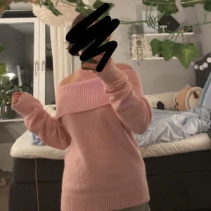 Rosa offshoulder tröja - Superfin rosa offshoulder tröja i stickat material. Perfekt för mysiga höstkvällar eller en avslappnad dag hemma. Den har långa ärmar och en ribbad kant vid ärmslut och nederkant. Passar perfekt för dig som gillar en bekväm och stilren look.