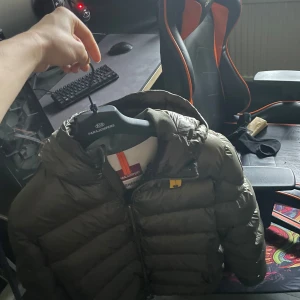 Grön dunjacka från Parajumpers - Säljer en snygg grön dunjacka från Parajumpers. Jackan har en quiltad design och dragkedja framtill. Perfekt för kyliga dagar med sin varma och bekväma passform. Den är storlek L men är lite stor för mig som är 176. Retail ligger på 6900