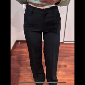 Mörkblå/svarta kostymbyxor - Snygga mörkblå/svarta kostymbyxor med hög midja och rak passform. Perfekta för en stilren look.