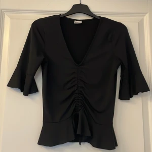 Topp med volanger - Fin topp med volanger, strl xs men passar även s. Använd fåtal gånger. 60kr