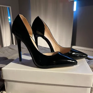 Svarta pumps med spetsig tå - Eleganta svarta pumps med hög klack och spetsig tå. Perfekta för en stilren look. Aldrig använda.