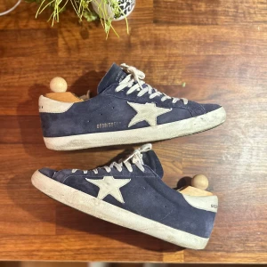 Golden Goose superstar mörk blå mocha INTRESSEKOLL - Tjena! Nu gör jag ett litet intressekoll på dessa tvär feta Golden goose superstar i mörkblå/ marin blå mocha. Dem är i allmänt bra skick med någon liten skada/ defekt som tex vid tungan och allt OG tillkommer vid köp utanför dustbag. Självklart 100% ÄKTA, kvitto finns! Byten är intressant men söker mesta dels då bara flycrews i liknande storlek. Förresten dem är HELT slutsålda överallt i nuläget för retail ( 6000 kr). 