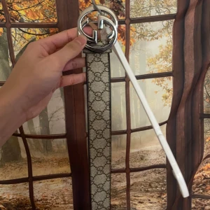 Beige och brunt bälte med silverdetaljer - Snyggt bälte med ett klassiskt mönster i beige och brunt. Bältet har en rund spänne i silver som ger en stilren look. Perfekt för att lyfta din outfit!