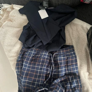 Pyjamasset - Snyggt pyjamasset med tillhörande byxor och tröja! Tröjan är aldrig använd och byxorna är i bra skick!