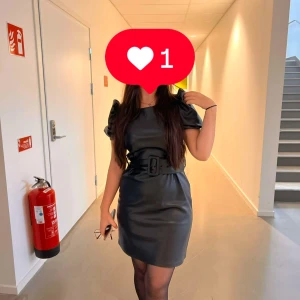 Svart klänning med bälte - Elegant svart klänning med korta ärmar och ett matchande bälte i midjan. 