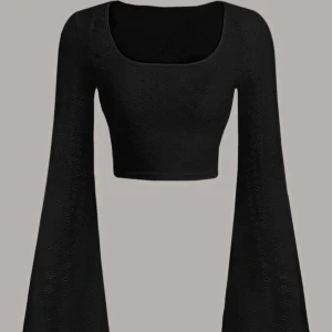 Svart topp - Snygg svart croppad topp med vida ärmar och ett diskret hålmönster. Perfekt för en trendig look.