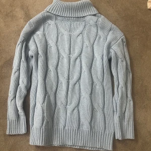 Ljusblå stickad polotröja från Bodyflirt - Mysig ljusblå stickad polotröja från Bodyflirt med ett snyggt kabelstickat mönster. Tröjan har långa ärmar och en hög krage som håller dig varm under kyliga dagar. Perfekt för höst och vinter! Säljer tröjan då jag aldrig riktigt haft tillfälle att använda den😔