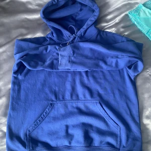 Blå hoodie - Säljer en blå hoodie med känguruficka och justerbar huva. Perfekt för en avslappnad stil. Oversized 