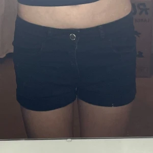 Svarta jeansshorts - Snygga svarta jeansshorts med knapp och dragkedja framtill. Perfekta för en sommar stil. De har en klassisk design med fickor och hällor för bälte. Kommer från H&M och kostar 200 i butik. Använt 2 gånger. Så snygga och sköna!! 