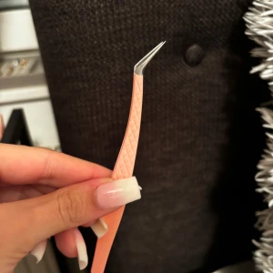 Rosa pincett med böjd spets - Snygg och praktisk rosa pincett med böjd spets för precisionsarbete. Perfekt för att plocka ögonbryn eller hantera små detaljer. Den har ett mönstrat grepp för bättre kontroll. Kan användas som separationspincett för fransförlängning🌺