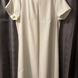 Vit klänning med dragkedja - Elegant vit klänning med korta ärmar och en stilren dragkedja i ryggen. Perfekt för en minimalistisk look.