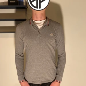 Moncler maglia piké  - Säljer en grå Moncler maglia pike i Storlek Xs ( passar S).  Säljes pga använder inte | säljes i befintligt skick.   Nypris 3899kr Mitt pris 699kr 