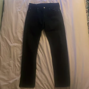 Levi’s jeans - Säljer ett par svarta jeans i storlek W30 L32. De är i bra skick och har en klassisk design med fem fickor och knappgylf. Perfekta för både vardag och fest!