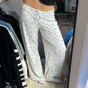 Blommiga byxor - Ass söta blommiga byxor från Lager 157. Inga defekter såsom hål eller fläckar. Fållade längst ner men passar bra på mig som är 160 cm. Väldigt gulligt mönster🥹🌸🫐