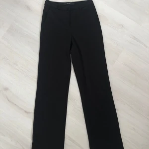 Svarta kostymbyxor från Vero Moda - Säljer ett par snygga svarta kostymbyxor från Vero Moda. De är högmidjade och har en klassisk rak passform. (Har använt en gång & är i perfekt skick)värde 400 kr 