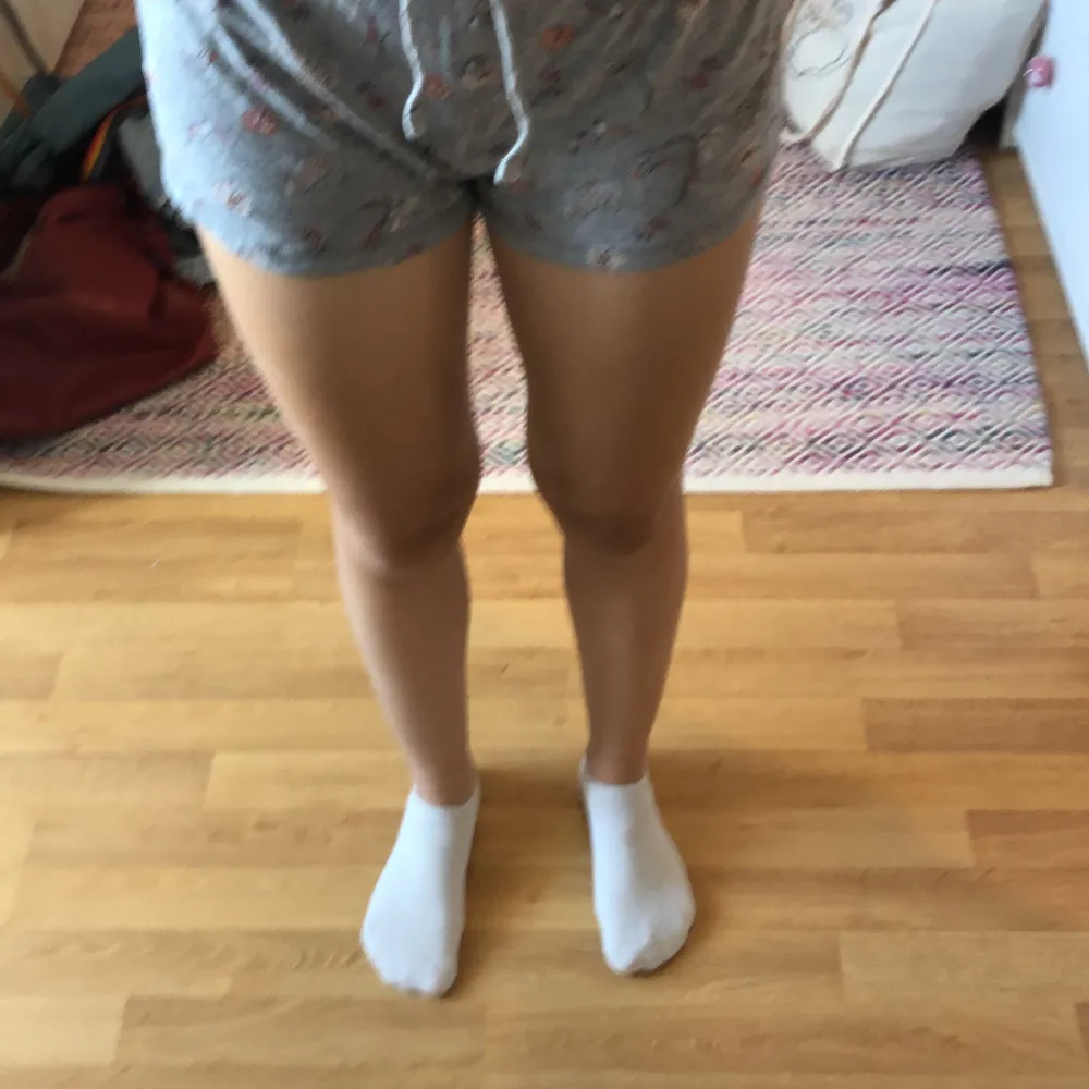 Säljer ett par grå shorts från Esmara i storlek XS. De är superbekväma och har ett fint blommigt mönster. Perfekta för sommaren eller att bara chilla hemma i. De har en dragsko i midjan för att justera passformen. Köp dem nu och njut av komforten! 🌸. Shortsit.