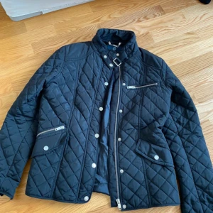 Svart quiltad jacka från Stockh LM - Säljer en snygg svart jacka från Stockh LM i storlek 42. Jackan har en stilren design med dragkedja och knappar framtill, och flera fickor med dragkedja och knappar. Perfekt för höst och vår! jag brukar ha storlek S/M i jackor så den är väldigt liten i storleken💕