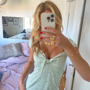 Ljusgrön blommig klänning med knyt - Säljer en superfin ljusgrön klänning med blommigt mönster. knytning framtill och korta ärmar🫶🏼🫶🏼 